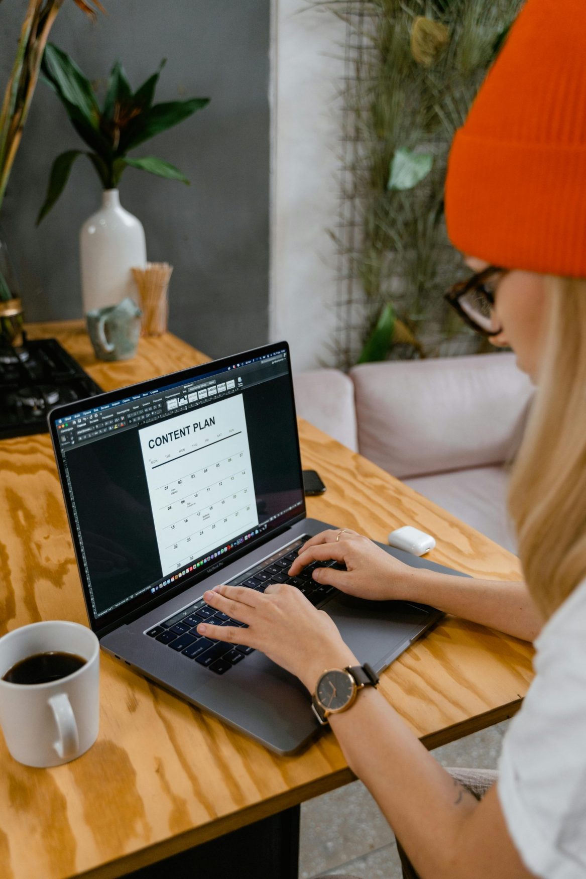 Content creator using AI assistant to plan weekly posts on laptop